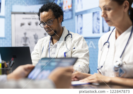 Medical experts collaborating on x ray analysis in a private clinic, collective work ensuring precise diagnostics and effective treatment plans. Highlighting professional healthcare teamwork. Medical experts collaborating on x ray analysis in a private clinic, collective work ensuring precise diagnostics and effective treatment plans. Highlighting professional healthcare teamwork. 122847873