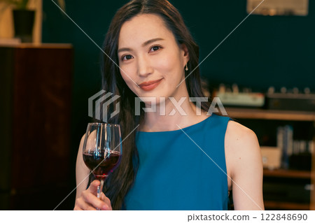 微笑的年輕女士拿著一杯葡萄酒 微笑的年輕女士拿著一杯葡萄酒 122848690