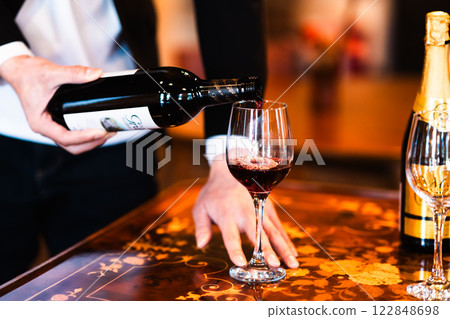 Waiter pouring wine in a restaurant, no face 122848698