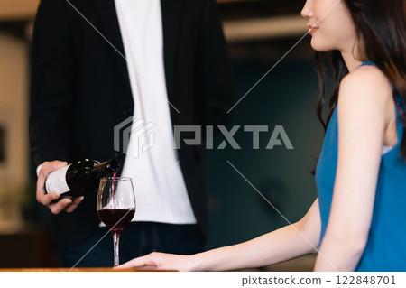 一名侍者正在倒酒，一名女子正在等待倒酒，沒有臉孔 122848701