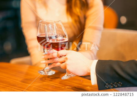 男人和女人在時尚的休息室啜飲葡萄酒，沒有臉孔 122848715