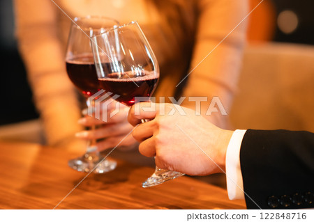 Men and women sipping wine glasses in a stylish lounge, no faces Men and women sipping wine glasses in a stylish lounge, no faces 122848716