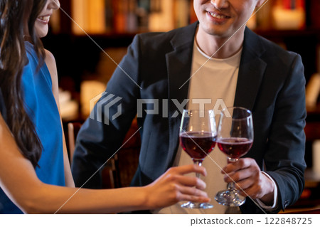 Men and women sipping wine glasses in a stylish lounge, no faces Men and women sipping wine glasses in a stylish lounge, no faces 122848725