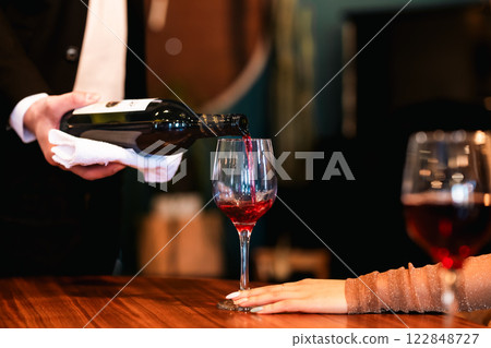 Waiter pouring wine and hand holding glass, no face Waiter pouring wine and hand holding glass, no face 122848727
