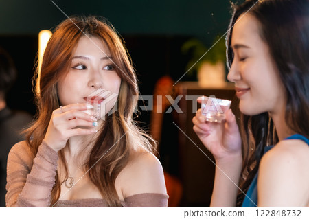 Young woman enjoying sake at a bar Young woman enjoying sake at a bar 122848732
