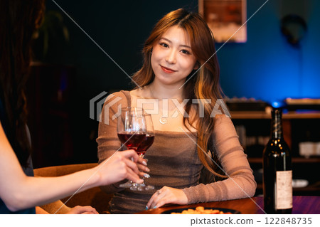 年輕女子在時尚酒吧裡一邊聽著黑膠唱片一邊享用一杯葡萄酒 122848735