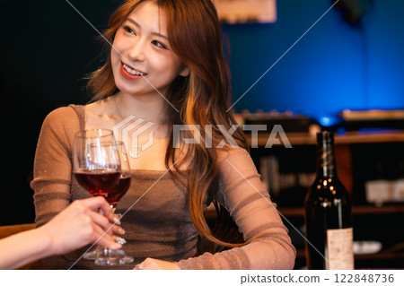 Young woman enjoying a glass of wine in a stylish bar with music on vinyl records Young woman enjoying a glass of wine in a stylish bar with music on vinyl records 122848736