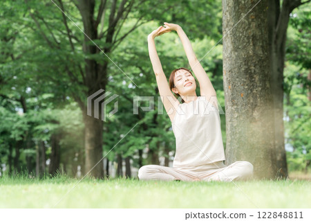 年輕的亞洲女性在公園做瑜珈、瑜珈、皮拉提斯、在森林/公園伸展運動 122848811