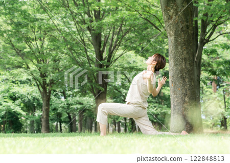 年輕的亞洲女性在公園做瑜珈、瑜珈、皮拉提斯、在森林/公園伸展運動 122848813