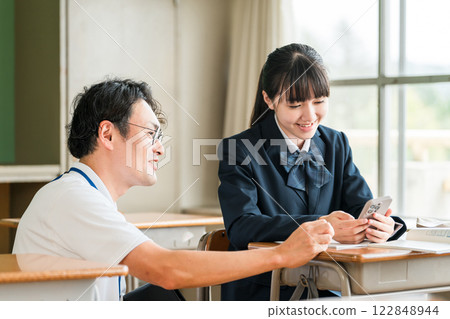 A teacher and a female student teaching using a smartphone (BYOD/ICT) 122848944