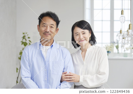 Portrait of a middle-aged couple in the living room, looking at the camera 122849436