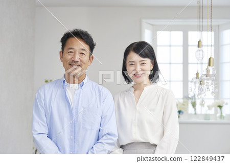 Portrait of a middle-aged couple in the living room, looking at the camera Portrait of a middle-aged couple in the living room, looking at the camera 122849437