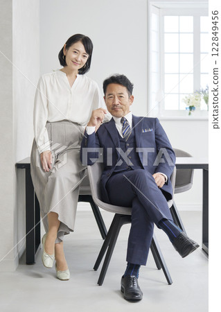 Portrait of businesswoman and businessman in office, looking at camera, full body Portrait of businesswoman and businessman in office, looking at camera, full body 122849456