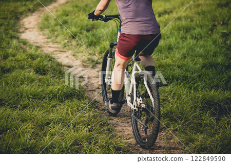 Woman mountain biking on mountain trail Woman mountain biking on mountain trail 122849590