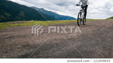 Riding mountain bike on grassland mountain top 122849693