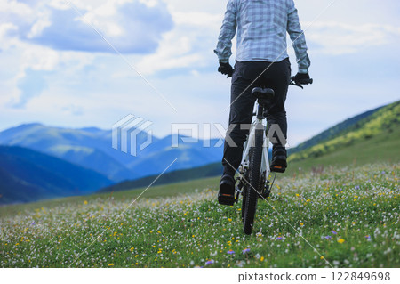 Riding mountain bike on flowering grassland mountain 122849698