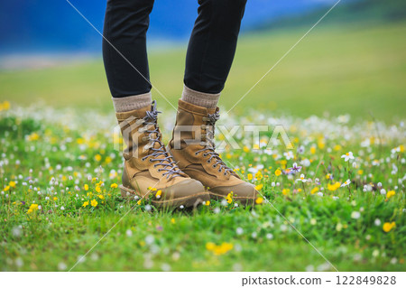 Hiker legs walking on beautiful flowering grassland 122849828