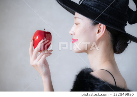 可愛的惡棍或女巫形象，萬聖節或角色扮演形象，吃蘋果 122849980