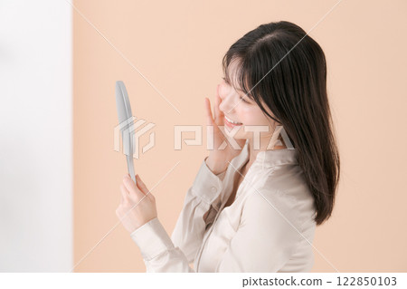 A profile of a woman looking at a mirror 122850103