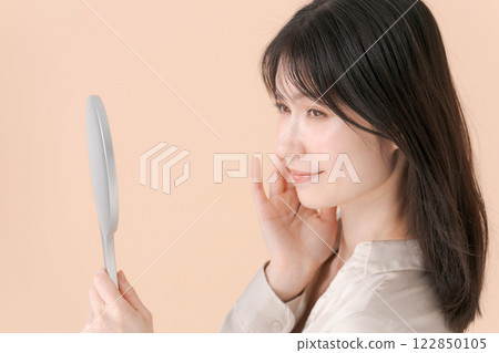 A profile of a woman looking at a mirror A profile of a woman looking at a mirror 122850105