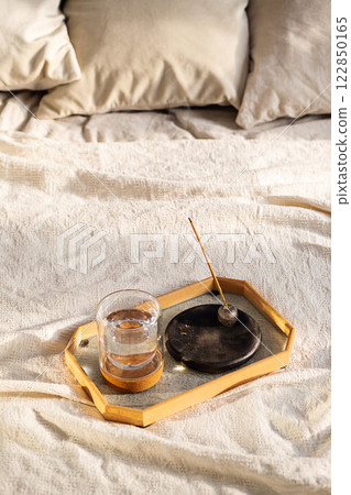 Smoldering Incense and Glass of Water on Tray in Bedroom. Morning Ritual. 122850165