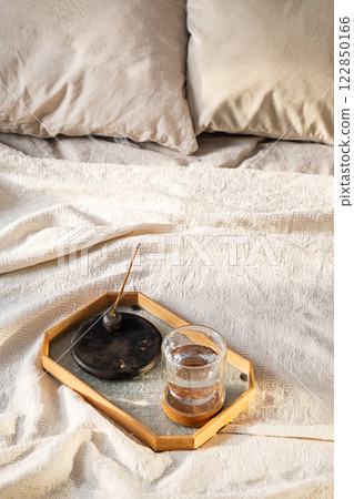 Smoldering Incense and Glass of Water on Tray in Bedroom. Morning Ritual. 122850166