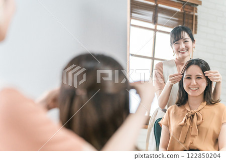 美髮師/造型師為在美容院/美髮沙龍諮詢髮型的亞洲女性顧客提供諮詢服務 美髮師/造型師為在美容院/美髮沙龍諮詢髮型的亞洲女性顧客提供諮詢服務 122850204