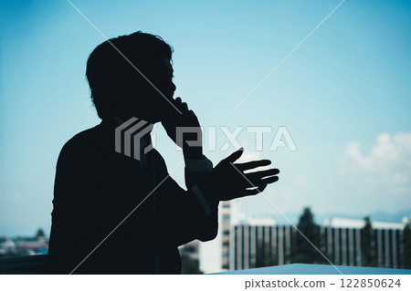 一位商人在電話裡交談的剪影 122850624
