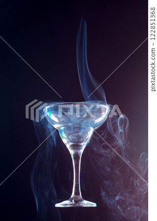 levitating glass full of smoke on a black background 122851368