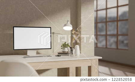 A computer and decorative items on a desk, set against a wall in a minimalist room. A computer and decorative items on a desk, set against a wall in a minimalist room. 122852058