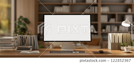 A computer and decorative items placed on a wooden desk in a contemporary cozy office. 122852367