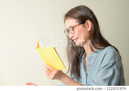 Senior woman with glasses enjoying reading Senior woman with glasses enjoying reading 122852974