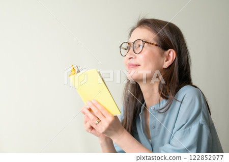 Senior woman with glasses enjoying reading Senior woman with glasses enjoying reading 122852977