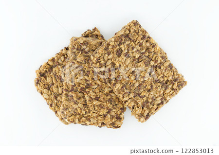 Delicious crunchy crackers with flax and sunflower seeds, perfectly stacked against a white backdrop 122853013