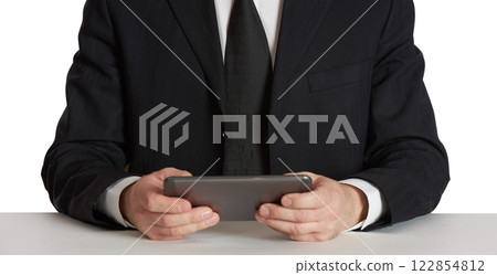 Businessman trader in a black suit with a tablet. Businessman trader in a black suit with a tablet. 122854812