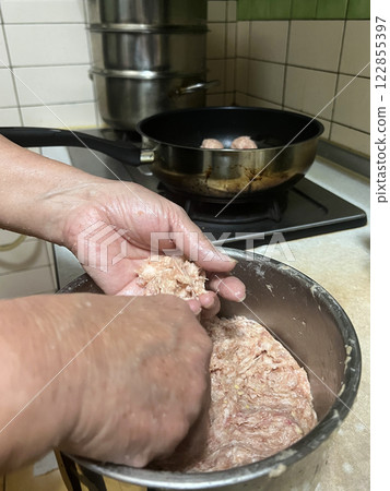 拍攝媽媽將豬肉末捏成圓形準備放入鍋中料理 122855397