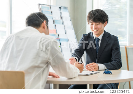 一位年輕的亞洲商人與一位男性顧客(汽車/保險)談判、服務和會面 一位年輕的亞洲商人與一位男性顧客(汽車/保險)談判、服務和會面 122855471