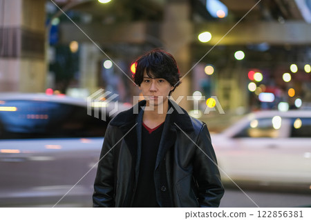 Young man walking in the night city Young man walking in the night city 122856381