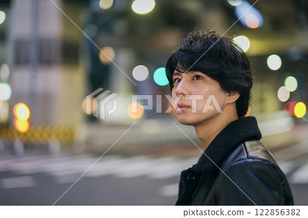 Close-up of a young man's face walking through the city at night Close-up of a young man's face walking through the city at night 122856382
