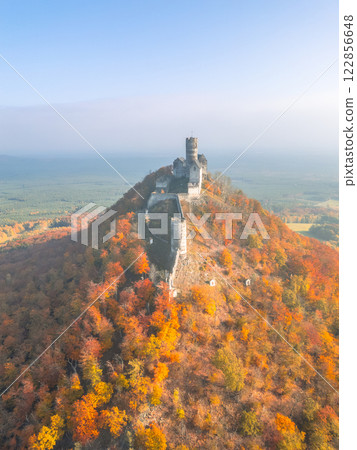 The medieval Bezdez castle stands majestically atop a hill, surrounded by vibrant autumn foliage. The colorful landscape showcases the beauty of fall in this historic location. The medieval Bezdez castle stands majestically atop a hill, surrounded by vibrant autumn foliage. The colorful landscape showcases the beauty of fall in this historic location. 122856648