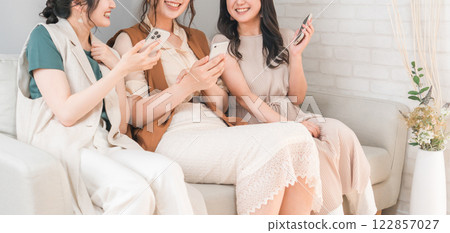 Women, friends, mom friends, and colleagues who use smartphones together at home Women, friends, mom friends, and colleagues who use smartphones together at home 122857027