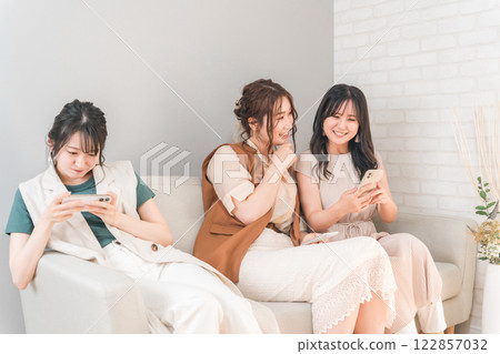 在家中一起使用智慧型手機的女性、朋友、媽媽朋友和同事 在家中一起使用智慧型手機的女性、朋友、媽媽朋友和同事 122857032