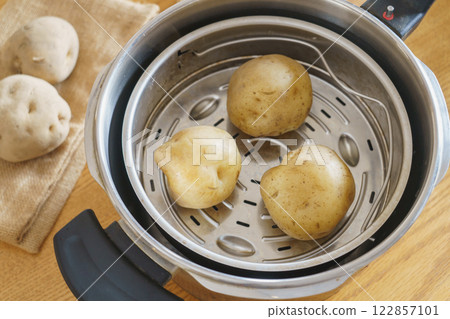Image of steaming potatoes in a pressure cooker 122857101