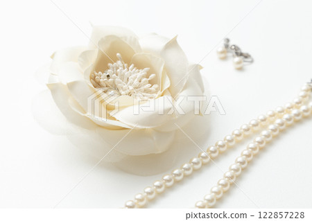 白色背景的花胸花和珍珠項鍊 白色背景的花胸花和珍珠項鍊 122857228
