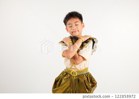 Portrait Thailand kid boy smiling traditional Thai dress costume hugging herself remember a moment, studio isolated white background, primary child love yourself carefree self care and self esteem 122858972