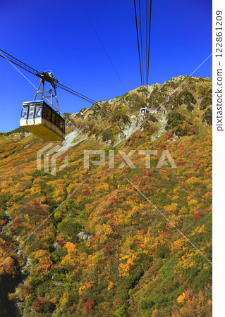 Beautiful autumn foliage and a ropeway under a blue sky in Kurobe, Mt. Tateyama Beautiful autumn foliage and a ropeway under a blue sky in Kurobe, Mt. Tateyama 122861209