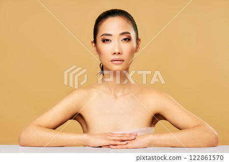 Beauty portrait of young woman with healthy skin and natural makeup over beige background 122861570