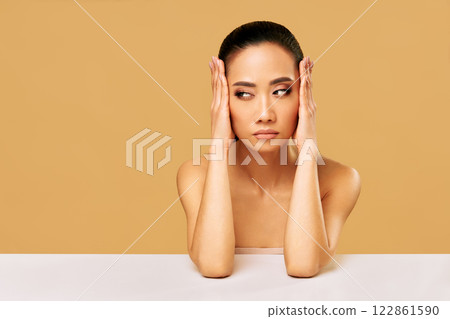 Young thoughtful woman thinking and looking aside on copy space isolated on beige background 122861590
