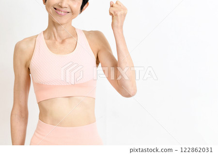 Middle-aged woman in gym wear posing with fist 122862031