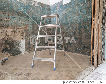 Interior of a room under construction with a ladder and a wall. House under construction Interior of a room under construction with a ladder and a wall. House under construction 122862162